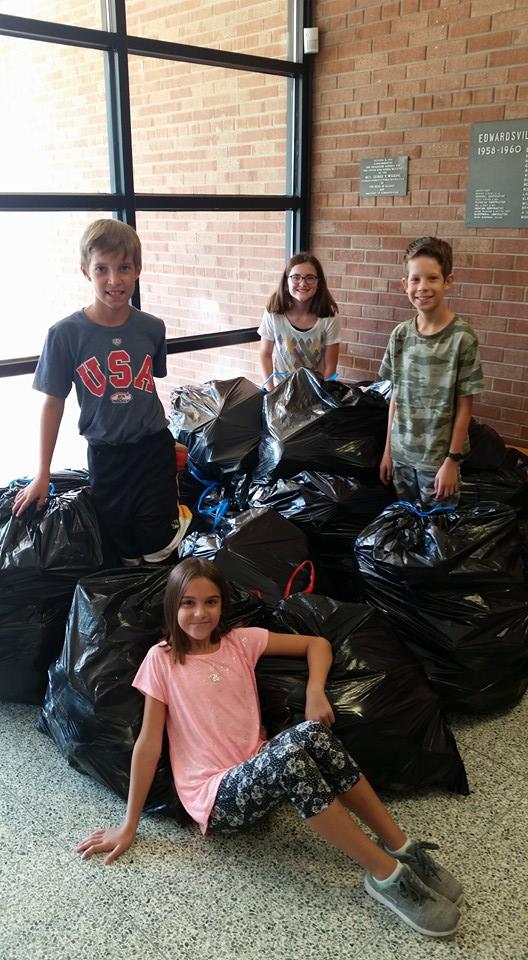 Woodland Elementary children display bags of shoes they have collected in their Shoeman Water Project campaign.