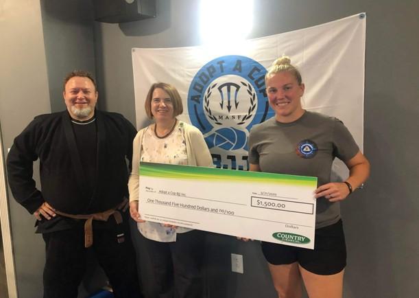 COUNTRY Financial Representative V. Deanne Stegeman (center) stands with (left to right) Deputy Brianne Markel and Keith Steinacher – owner of Strategic BJJ Gym in Alton, IL.