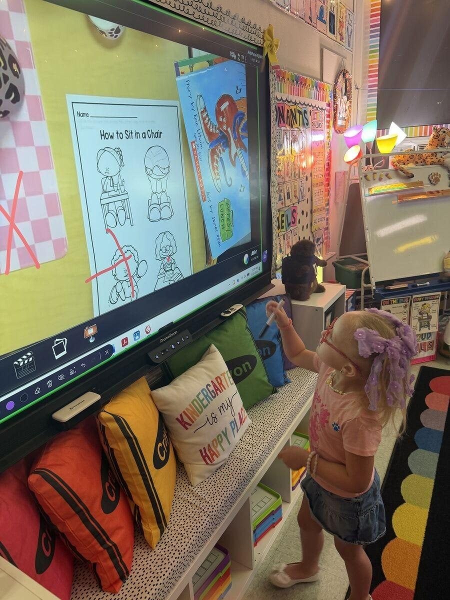 A student learns how to sit in a chair properly.