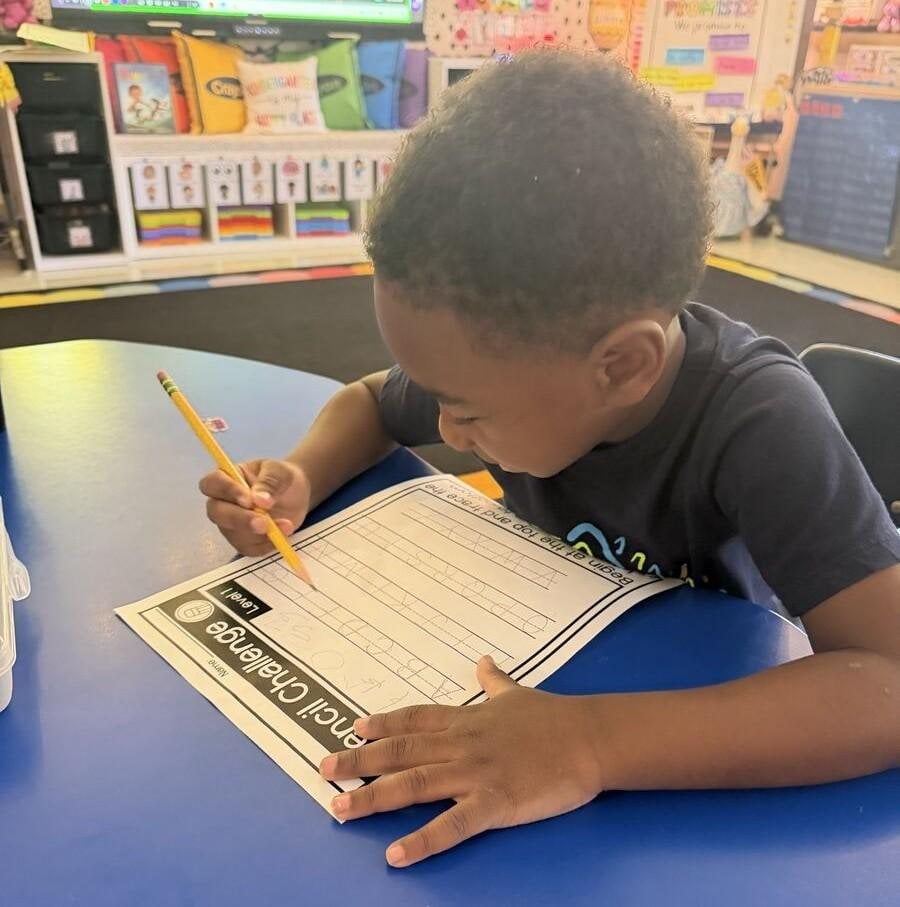 A student learns how to use a pencil.