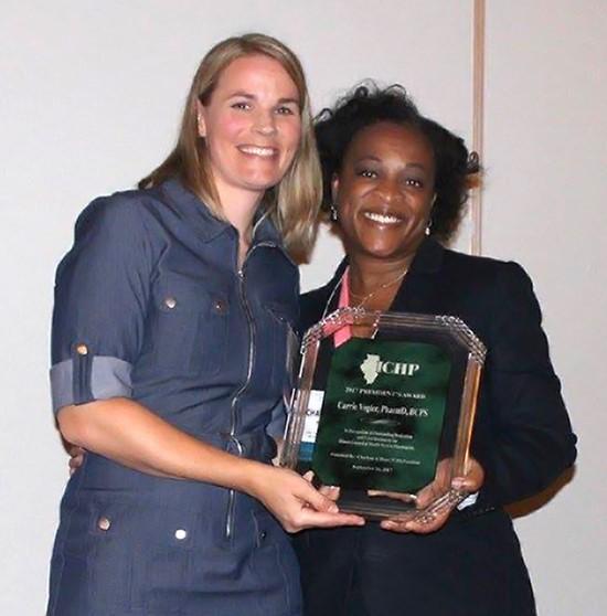 Carrie Vogler (left), PharmD, clinical associate professor in the SIUE School of Pharmacy Department of Pharmacy Practice, receives the President’s Award from ICHP President Charlene Hope.