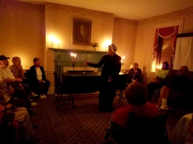 Docent Diane Schrader discusses 1822 mourning customs in the parlor with a group of visitors.