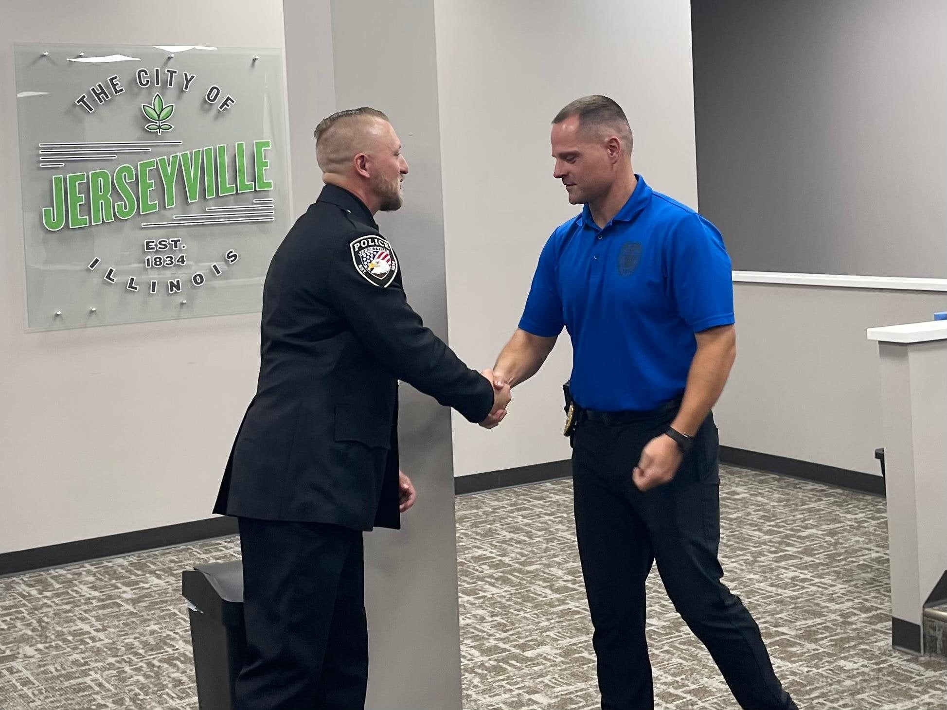 Jerseyville Police Sergeant Nick Woelfel (left) and Chief Danny Green (right) shake hands shortly after Woelfel's promotion is made official.