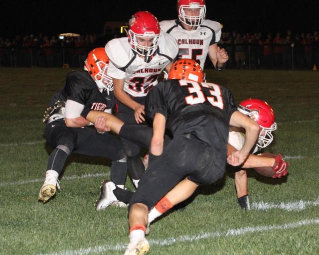  Calhoun’s Wes Klocke dives for yardage as Greenfield-Northwestern’s Keith Elliott steer ropes an ankle to bring Klocke down with help from Klinton Roth. Warriors Josh Wieneke and Luke Eberlin are too late to help Klocke. Calhoun defeated the Tigers in the WIVC South contest 18-14.