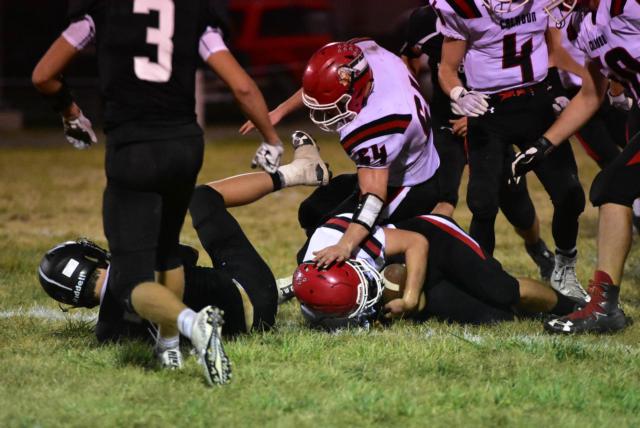Trenton Buchanan, #64, attempts to avoid falling on #7, Ty Bick, after a yardage gain.