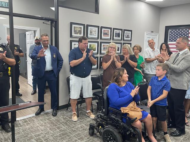 New Police Chief Daniel Green (right) joins meeting attendees in applauding former Police Chief Brad Blackorby (left) shortly after City Council members accepted his retirement letter.