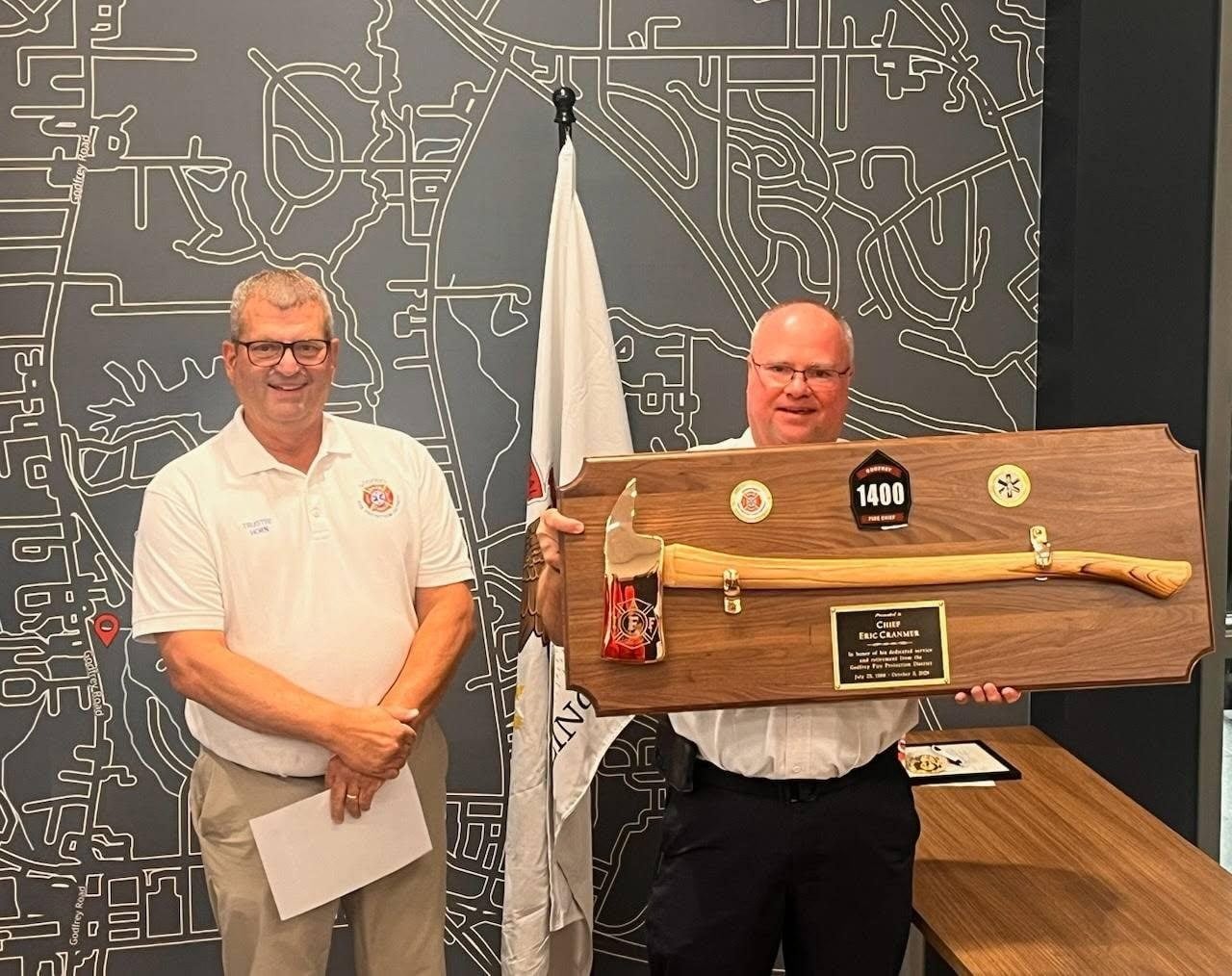 Retiring Chief Eric Cranmer (right) is presented with an award by Trustee Matt Horn (left).